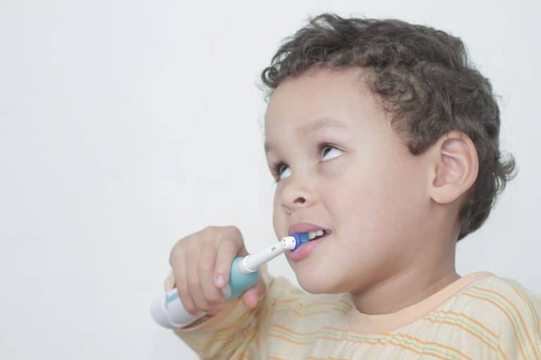 Brosse à dent électrique tenue par un enfant