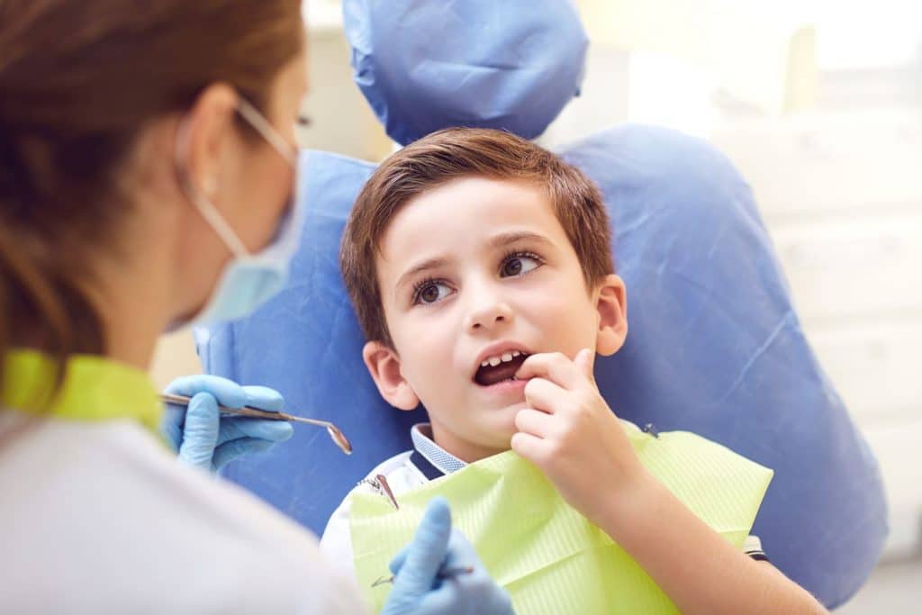 Child in consultation with the dentist for a tooth that grows in the palate