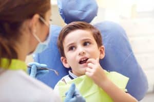Enfant en consultation chez les dentiste pour une dent qui pousse dans le palais