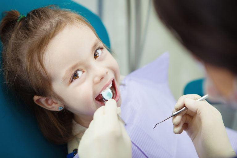 Petite fille en visite chez le dentiste pour enfant